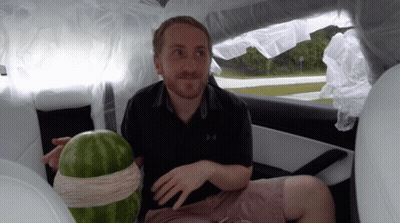 A Man In An Under Armour Shirt Sits In A Car GIF