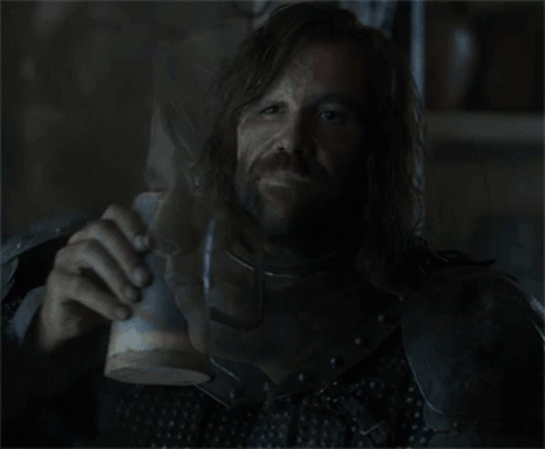 A Man In Armor Drinks From A Wooden Cup GIF