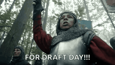 A Man In Armor Is Holding A Sword In A Forest And Says `` For Draft Day ! '' GIF