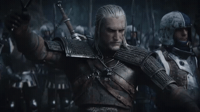 A Man In Armor Is Holding A Sword In Front Of A Group Of Men . GIF