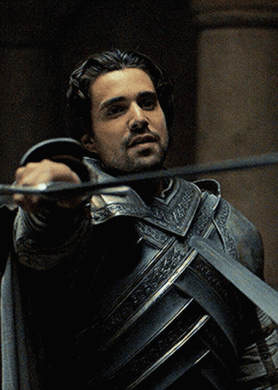 A Man In Armor Is Holding A Sword GIF