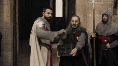 A Man In Armor Is Holding A Treasure Chest GIF