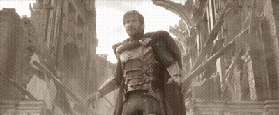 A Man In Armor Is Standing In Front Of A Brick Building GIF