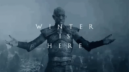 A Man In Armor Is Standing In Front Of A Crowd Of People With His Arms Outstretched And The Words `` Winter Is Here '' . GIF
