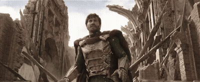 A Man In Armor Is Standing In Front Of A Destroyed Building GIF
