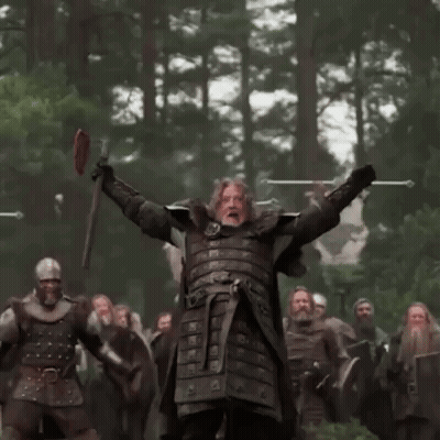 A Man In Armor Is Standing In Front Of A Group Of Soldiers Holding Swords . GIF