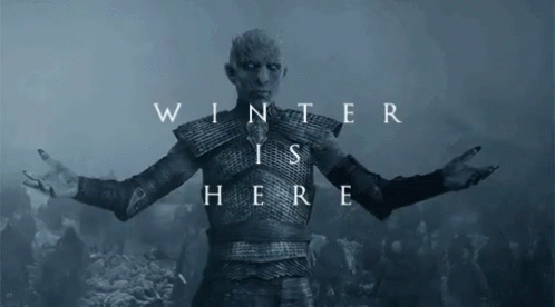 A Man In Armor Is Standing In Front Of A Sign That Says Winter Is Here GIF