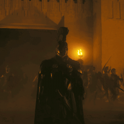 A Man In Armor Is Standing In Front Of A Wall With The Letter J Written On It GIF