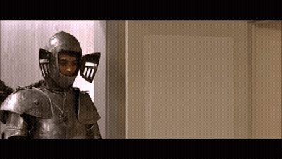 A Man In Armor Is Standing In Front Of A White Door GIF