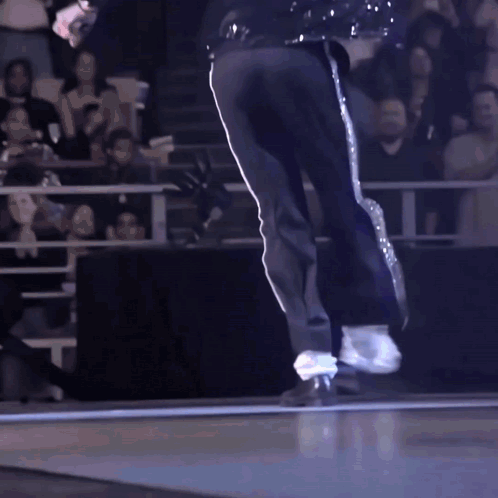 A Man In Black Pants And White Stripes Is Dancing On A Stage GIF