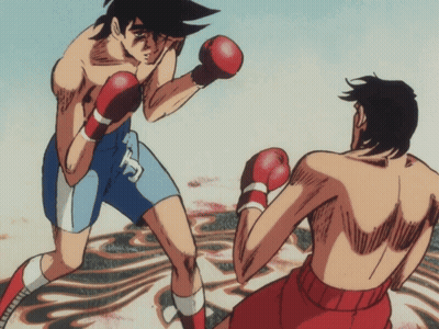 A Man In Boxing Gloves With The Letter T On His Shirt GIF