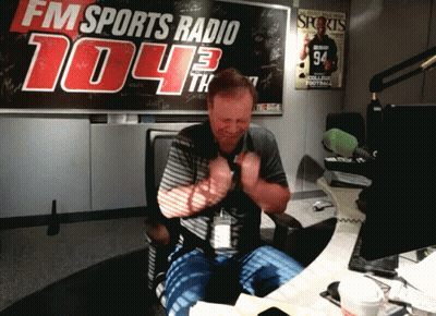 A Man In Front Of A Fm Sports Radio Sign GIF