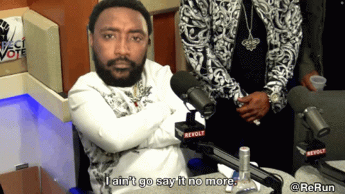 A Man In Front Of A Microphone That Says Revolt On It GIF