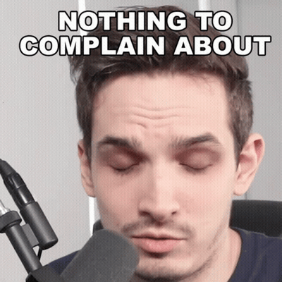 A Man In Front Of A Microphone With The Words Nothing To Complain About Written Above Him GIF