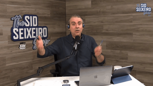 A Man In Front Of A Sign That Says The Sid Seixeiro On It GIF