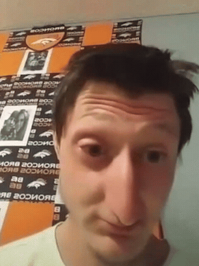 A Man In Front Of A Wall With Denver Broncos Stickers GIF