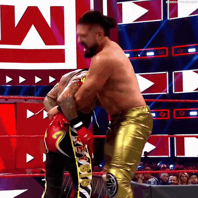 A Man In Gold Pants Is Wrestling Another Man In Red GIF