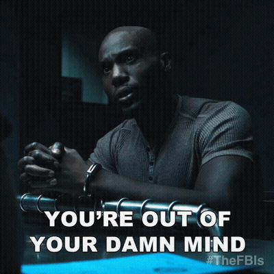 A Man In Handcuffs Is Sitting At A Table With The Words You 'Re Out Of Your Damn Mind GIF