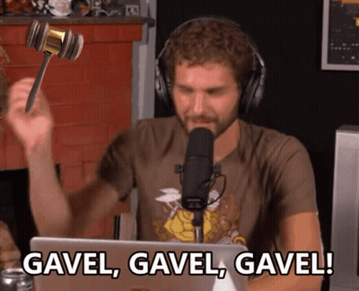 A Man In Headphones Is Holding A Gavel In Front Of A Microphone And Says Gavel Gavel Gavel GIF