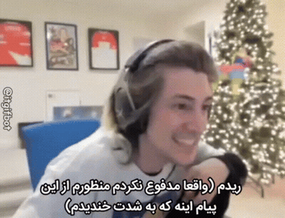 A Man In Headphones Is Smiling In Front Of A Christmas Tree . GIF