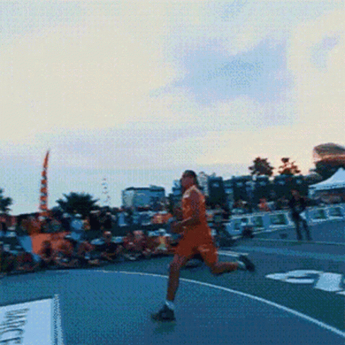 A Man In Orange Shorts Is Running On A Basketball Court In Front Of A Sign That Says " Magic " GIF