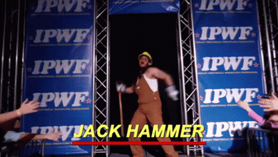 A Man In Overalls And A Hard Hat Is Standing In Front Of A Row Of Ipwf Banners GIF