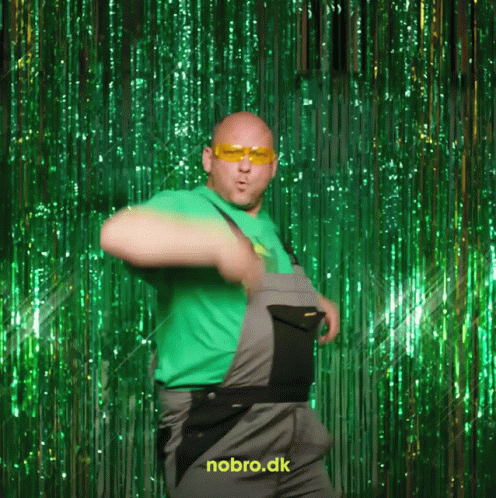 A Man In Overalls Is Dancing In Front Of A Green Curtain That Says Nobro.dk On It GIF