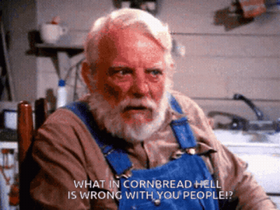 A Man In Overalls Is Sitting In A Chair And Says What In Cornbread Hell Is Wrong With You People GIF
