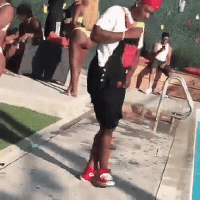 A Man In Overalls Is Standing Next To A Swimming Pool . GIF