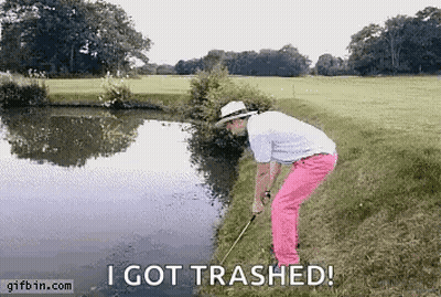 A Man In Pink Pants Is Holding A Golf Club Next To A Body Of Water And Says " I Got Trashed " GIF