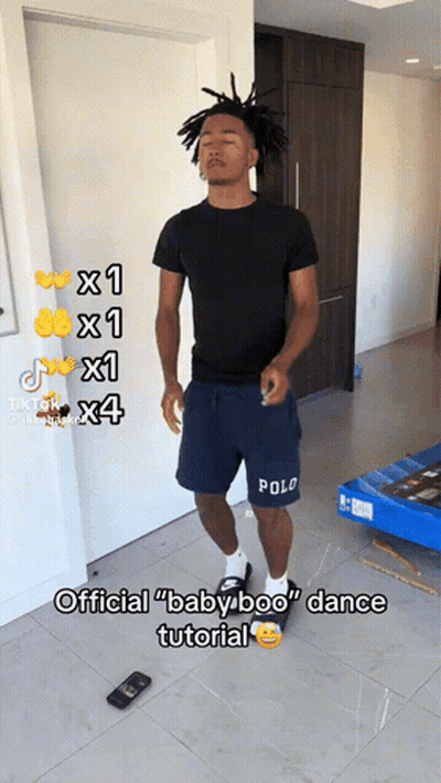 A Man In Polo Shorts Is Standing In A Room GIF