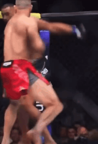 A Man In Red Shorts Is Kicking Another Man In The Face GIF