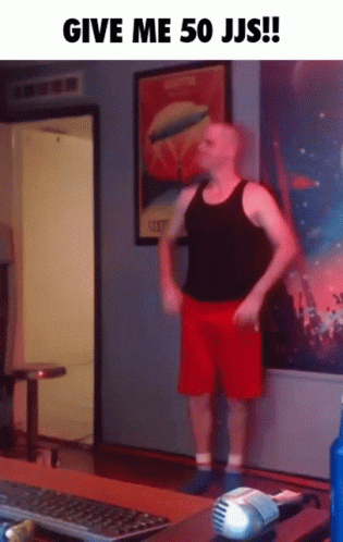 A Man In Red Shorts Is Standing In Front Of A Computer Keyboard GIF