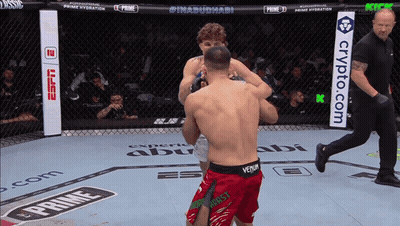 A Man In Red Shorts With The Word Venum On Them Is Fighting Another Man GIF