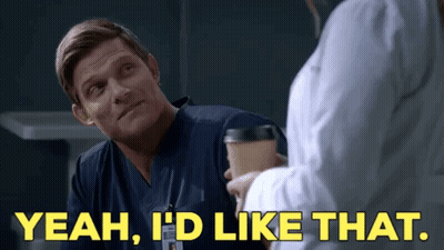 A Man In Scrubs Is Talking To A Woman In A Lab Coat While Holding A Coffee Cup . GIF