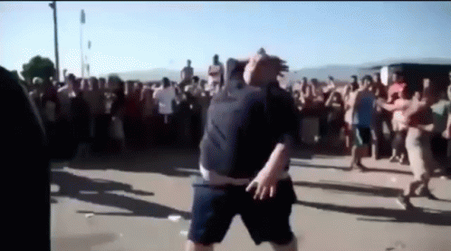 A Man In Shorts Is Dancing In Front Of A Crowd GIF