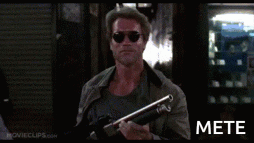 A Man In Sunglasses Is Holding A Shotgun And The Word Mete Is On The Bottom Right GIF