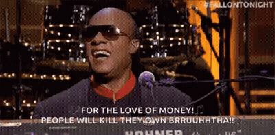 A Man In Sunglasses Is Singing Into A Microphone While Playing A Keyboard . GIF