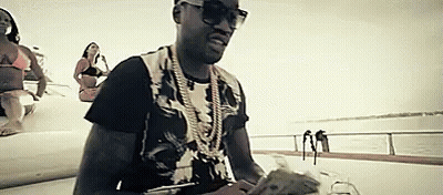 A Man In Sunglasses Is Sitting On A Boat Holding Money . GIF
