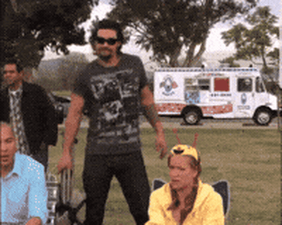 A Man In Sunglasses Stands In Front Of A White Ice Cream Truck GIF