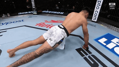 A Man In Ufc Shorts Is Doing A Stretch GIF