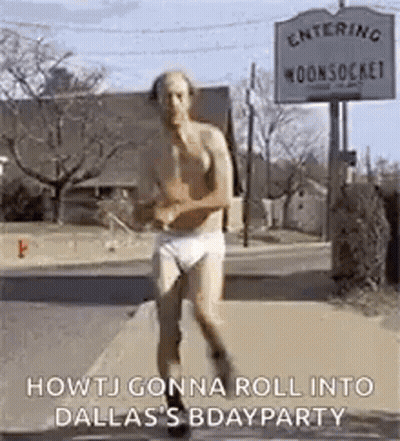 A Man In Underwear Is Running Down A Street . GIF