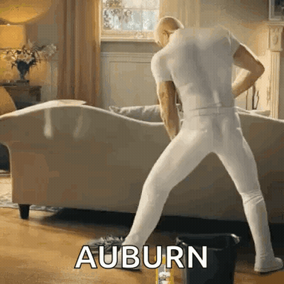 A Man In White Underwear Is Dancing In A Living Room With The Word Auburn Written On The Floor GIF