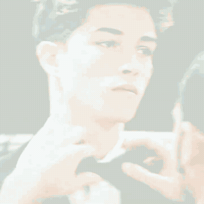 A Man Is Adjusting Another Man 'S Bow Tie In Front Of A Mirror GIF