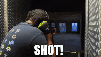 A Man Is Aiming A Gun At A Target And The Word Shot Is On The Bottom Right GIF
