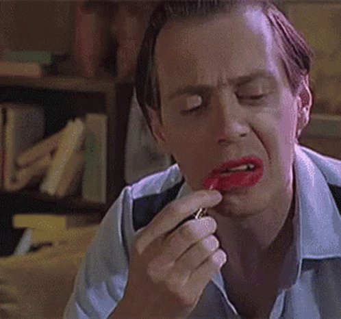 A Man Is Applying Red Lipstick To His Lips And Making A Funny Face . GIF