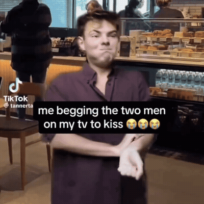 A Man Is Begging The Two Men On His Tv To Kiss In A Tik Tok Video GIF