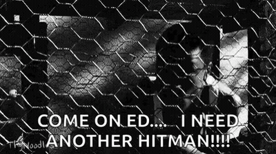 A Man Is Behind A Chain Link Fence And Says `` Come On Ed ... I Need Another Hitman !! '' GIF
