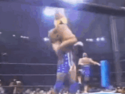 A Man Is Being Lifted In The Air By Another Man In A Wrestling Match . GIF
