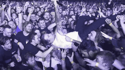 A Man Is Being Lifted Up In The Air By A Crowd Of People GIF